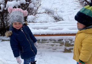 dwóch chłopców na śniegu stoją i się śmieją